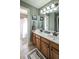 Well-lit bathroom featuring double vanity, decorative mirror, and a shower with a modern shower curtain at 9742 Fallview Ct, Villa Rica, GA 30180