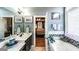 Bright bathroom with a double sink, walk-in closet, tub, and nice decorative tiling at 9742 Fallview Ct, Villa Rica, GA 30180