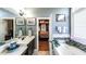 Bright bathroom with double sinks, tile floors, and soaking tub near the main bedroom at 9742 Fallview Ct, Villa Rica, GA 30180