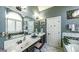Bright bathroom with double sinks, a large framed mirror, and a tub at 9742 Fallview Ct, Villa Rica, GA 30180