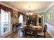 Traditional dining room boasts hardwood floors, a wooden table, and natural light from large windows at 9742 Fallview Ct, Villa Rica, GA 30180