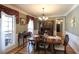 Light-filled dining room features hardwood floors, elegant molding, and an ornate chandelier at 9742 Fallview Ct, Villa Rica, GA 30180