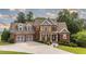 Charming two-story brick home featuring a well-manicured lawn, a driveway to a two-car garage, and decorative landscaping at 9742 Fallview Ct, Villa Rica, GA 30180