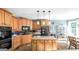 Modern kitchen featuring an island with bar stools, wood cabinets, and stainless steel appliances at 9742 Fallview Ct, Villa Rica, GA 30180