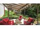 A cozy covered patio with comfortable red seating is ideal for outdoor relaxation and entertaining at 9742 Fallview Ct, Villa Rica, GA 30180