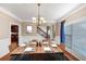 Elegant dining room featuring a chandelier and set table adjacent to the staircase at 101 Lumby Ln, Stockbridge, GA 30281