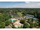 Aerial view of a community featuring a lake, swimming pool, tennis courts, and golf course, all surrounded by lush greenery at 1023 Little Darby Ln, Suwanee, GA 30024