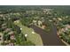 Lush aerial view of a verdant golf course and lake surrounded by trees and luxury homes at 1023 Little Darby Ln, Suwanee, GA 30024