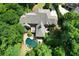 Aerial view showcasing a private estate with pool, deck, lush landscaping, and well-maintained lawn at 1023 Little Darby Ln, Suwanee, GA 30024