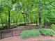Landscaped backyard with a black fence and a view of the trees and shrubs at 1023 Little Darby Ln, Suwanee, GA 30024