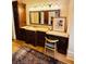 Bathroom features dark wood cabinets, granite countertops, a large mirror, and a chair at the vanity at 1023 Little Darby Ln, Suwanee, GA 30024