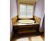 A relaxing soaking tub is framed by a picture window providing natural light and scenic views at 1023 Little Darby Ln, Suwanee, GA 30024