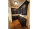 Butler's pantry with dark cabinetry, granite countertop, and tile backsplash at 1023 Little Darby Ln, Suwanee, GA 30024