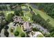Aerial shot of a large clubhouse nestled amongst a golf course and a lake with beautiful grounds and parking at 1023 Little Darby Ln, Suwanee, GA 30024