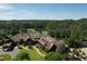 Aerial view of a clubhouse overlooking a lush golf course with a lake, and mature trees at 1023 Little Darby Ln, Suwanee, GA 30024