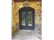 Elegant wrought iron double front doors with stone surround and lighting at 1023 Little Darby Ln, Suwanee, GA 30024