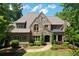 Stunning stone home featuring manicured landscaping, arched entryway, and a charming walkway to the front door at 1023 Little Darby Ln, Suwanee, GA 30024