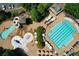 Aerial view of a community pool with a slide, fountains, lounge chairs, and umbrellas, perfect for relaxing at 1023 Little Darby Ln, Suwanee, GA 30024