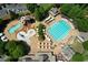 Aerial view of a community pool featuring a lap pool, waterslides, lounge chairs, and umbrella-covered tables at 1023 Little Darby Ln, Suwanee, GA 30024
