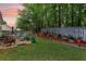 Landscaped backyard features a patio with seating, flower beds, and a wooded backdrop at 3388 Washington Cmns Nw Ave, Kennesaw, GA 30144