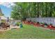 Landscaped backyard with a variety of potted plants and flowers along a mulched flowerbed and green lawn at 3388 Washington Cmns Nw Ave, Kennesaw, GA 30144