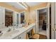 Bathroom with dual sink vanity, large mirror, and doorway leading to bedroom with ceiling fan at 3388 Washington Cmns Nw Ave, Kennesaw, GA 30144
