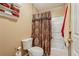 Cozy bathroom featuring a toilet, towel rack and a shower and tub combination with a decorative curtain at 3388 Washington Cmns Nw Ave, Kennesaw, GA 30144