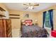 Comfortable bedroom with wood furniture, ceiling fan, window with curtains, and decorative shelves at 3388 Washington Cmns Nw Ave, Kennesaw, GA 30144