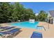 Community pool area with lounge chairs and clear blue water surrounded by trees at 3388 Washington Cmns Nw Ave, Kennesaw, GA 30144
