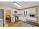 Modern kitchen with white cabinets, stainless steel appliances, and wood floors, adjacent to the dining area at 3388 Washington Cmns Nw Ave, Kennesaw, GA 30144