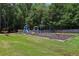 Community playground with swings, a slide, and other play equipment on a mulch base and green lawn at 3388 Washington Cmns Nw Ave, Kennesaw, GA 30144