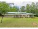 Beautiful home with green metal roof, front lawn, manicured shrubbery, and stone features beneath the windows at 379 Bohannon Rd, Grantville, GA 30220
