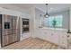 Modern kitchen with stainless steel refrigerator, double ovens, white cabinets, and wood look flooring at 379 Bohannon Rd, Grantville, GA 30220