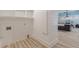 Well-lit laundry room with shiplap walls and wood-style flooring, featuring washer/dryer hookups and built-in shelving at 379 Bohannon Rd, Grantville, GA 30220