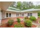 Picturesque patio featuring multi-door access, red-stained wood deck and beautifully landscaped garden with an adjacent grassy lawn at 379 Bohannon Rd, Grantville, GA 30220