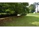 Large, well-manicured front lawn with mature trees and landscaping, located on a corner lot at 5517 Rock Shoals Way, Atlanta, GA 30349