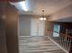 Hallway featuring modern wood-look floors, stairs with wood railing, and a stylish chandelier at 5517 Rock Shoals Way, Atlanta, GA 30349