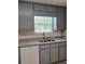 Gray kitchen with stainless steel sink, window, and gray cabinets at 5517 Rock Shoals Way, Atlanta, GA 30349