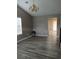 Bright living room with vaulted ceilings, modern chandelier, and stylish gray laminate flooring at 5517 Rock Shoals Way, Atlanta, GA 30349