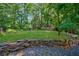Beautifully landscaped backyard featuring a stone retaining wall and lush green lawn, surrounded by mature trees at 1146 Cumberland Ne Rd, Atlanta, GA 30306