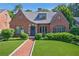 Charming brick home featuring a manicured lawn, arched entryway, and quaint architectural details at 1146 Cumberland Ne Rd, Atlanta, GA 30306