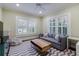 Comfortable living room with a plush sofa, chevron rug, and bright natural light from shuttered windows at 1146 Cumberland Ne Rd, Atlanta, GA 30306