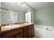 Bathroom with double sinks, modern vanity, and a soaking tub at 212 Ranier Court, Canton, GA 30114