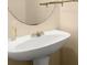 Close-up of a pedestal sink and vanity mirror in a neutrally decorated bathroom at 212 Ranier Court, Canton, GA 30114