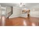 Open-concept living area featuring hardwood floors, access to the staircase, and a kitchen at 212 Ranier Court, Canton, GA 30114