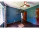 Bedroom featuring dark blue walls, hardwood floors, ceiling fan, shelves, and window at 3020 Washington Rd, East Point, GA 30344