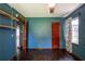Bedroom featuring dark blue walls, hardwood floors, shelves, and window at 3020 Washington Rd, East Point, GA 30344
