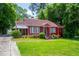 Quaint red brick home featuring a well-kept lawn and mature trees in a lovely neighborhood at 3020 Washington Rd, East Point, GA 30344