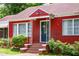 Close up of an attractive red brick house with a decorative door and well-maintained landscaping at 3020 Washington Rd, East Point, GA 30344