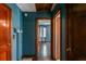 Hallway with wood doors, dark teal paint, and stained wood floors leading to a room with a window at 3020 Washington Rd, East Point, GA 30344